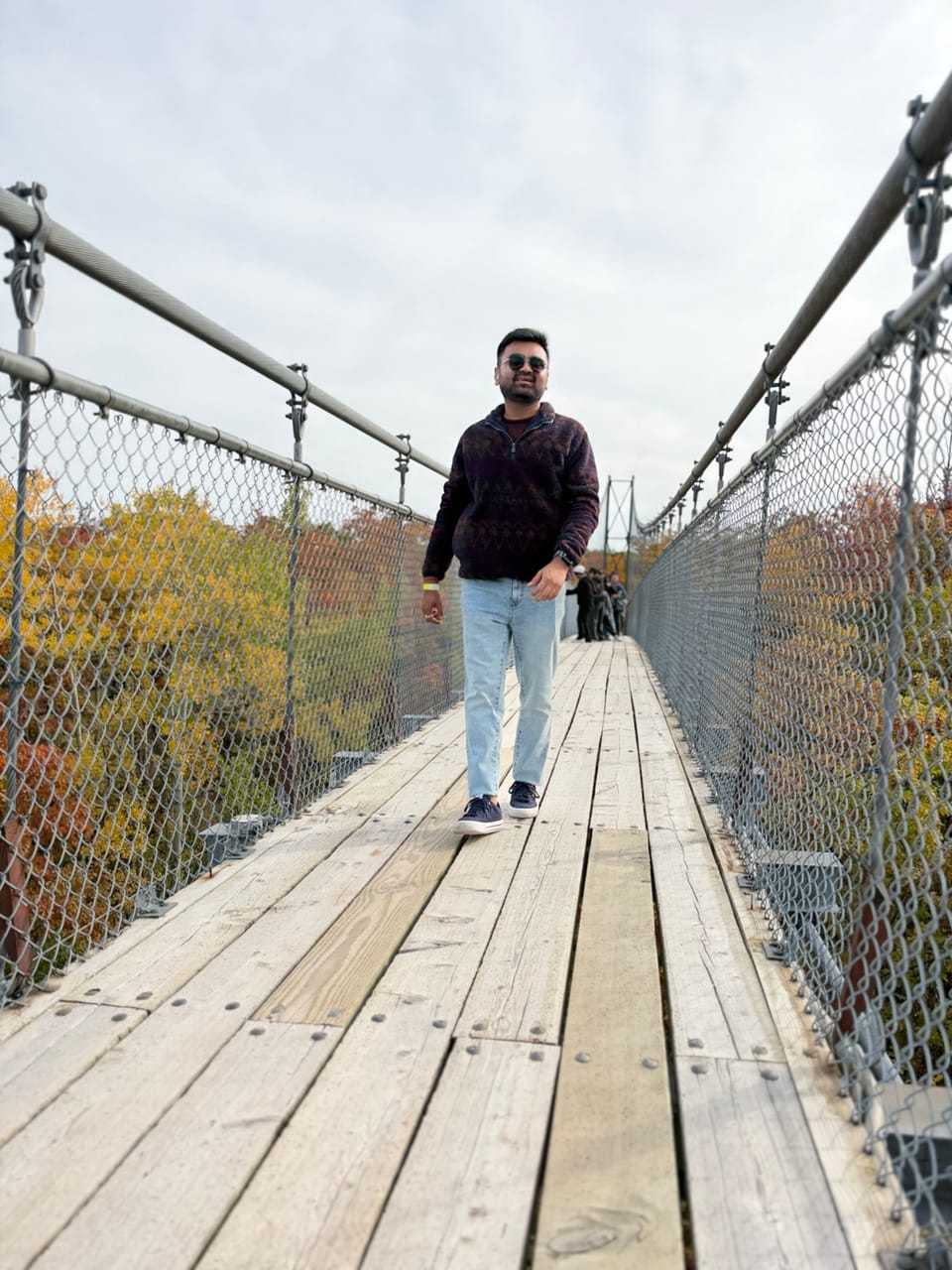 Bhargav Patel on a suspension footbridge in autumn